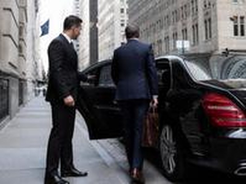 Chauffeur opening a car door for a business traveler in Manhattan